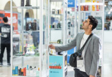 MJ Unpacked: Why Experience Trumps Price in Cannabis Retail An attendee examines a glass product display on the show floor at the MJ Unpacked cannabis trade show in Atlantic City, 2025.