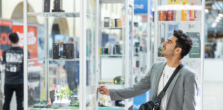 MJ Unpacked: Why Experience Trumps Price in Cannabis Retail An attendee examines a glass product display on the show floor at the MJ Unpacked cannabis trade show in Atlantic City, 2025.