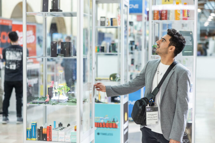 An attendee examines a glass product display on the show floor at the MJ Unpacked cannabis trade show in Atlantic City, 2025.