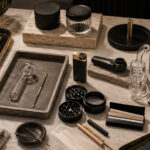 The Next Big Dispensary Margin Play Upscale retail accessories arranged on a marble surface, including grinders, glass pipes, rolling papers, trays, and storage containers.