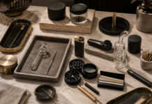 The Next Big Dispensary Margin Play Upscale retail accessories arranged on a marble surface, including grinders, glass pipes, rolling papers, trays, and storage containers.