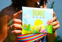 Opinion: Why Cannabis Brands Should Champion Original Art A person holds a colorful illustrated package featuring original cactus-and-flower artwork.