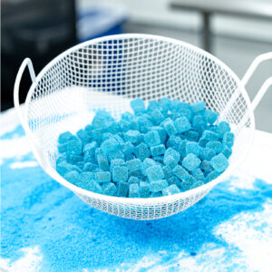 Blue sugar-coated gummies in a production kitchen.