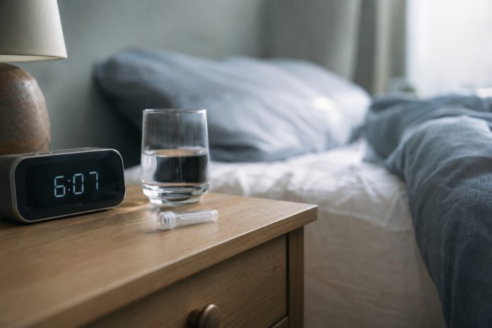 frequent cannabis use waking cortisol study Saliva collection tube beside a clock and water glass in early morning light