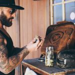 The Cannabis Industry Is Optimizing the Wrong Thing Sean Oganesyan examines cannabis flower at a wooden workbench.