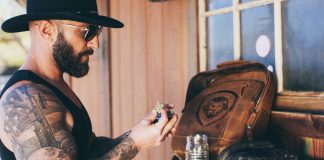 The Cannabis Industry Is Optimizing the Wrong Thing Sean Oganesyan examines cannabis flower at a wooden workbench.
