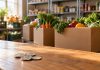 What $1,100 Taught Me About Cannabis Philanthropy Four quarters on a wooden counter in front of boxes of fresh produce at a community food pantry.