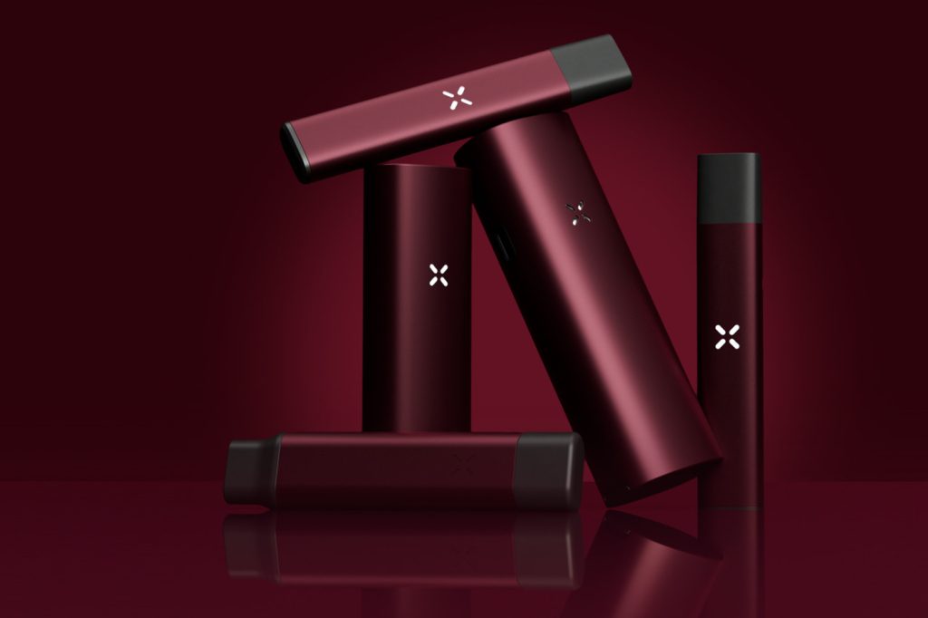 PAX vaporizer devices in a deep burgundy Oxblood finish arranged against a matching dark red background.