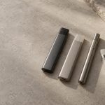 Unbranded integrated vaporizers beside a reusable battery and cartridge.