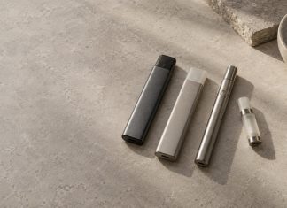 Unbranded integrated vaporizers beside a reusable battery and cartridge.